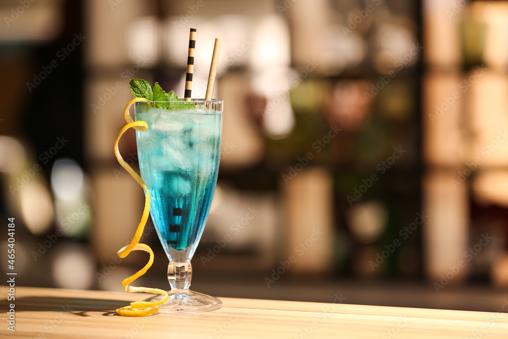 Glass of Blue Lagoon cocktail on table in bar Glass of Blue Lagoon cocktail on table in bar