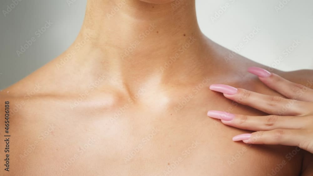 Young woman touching clavicles close-up, model with smooth healthy skin. Female shoulders, naked body. Beauty and body care concept. Unrecognizable person with bare neck and chest on white background. Young woman touching clavicles close-up, model with smooth healthy skin. Female shoulders, naked body. Beauty and body care concept. Unrecognizable person with bare neck and chest on white background.