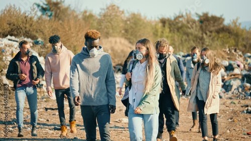 Group of Young People in Gas Masks Going Through the Toxic Smoke in a Garbage Dump. People Care About Ecology. Young Activists in Action Against Pollution Stay at a Landfill Site. Saving the Planet.