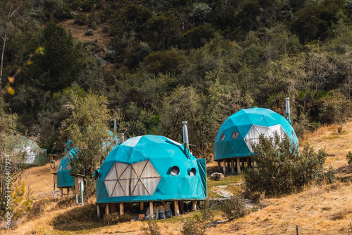 camping in the Andes mountain range outdoor camping tents on a sunny day with clouds and a blue sky surrounded by green vegetation