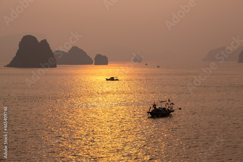 Golden Hazy Dawn Sunrise at Halong Bay, Vietnam with Fishing Boats Silhouetted in the Early Light