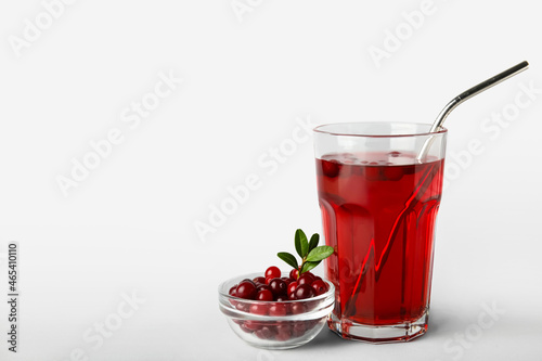 Glass with healthy cranberry juice on light background