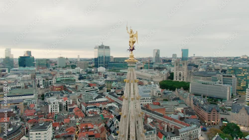 Aerial View of Gothic Tower of Brussels Town Hall with statue of Saint Michael. Grand Place in Bruxelles, Belgium. Popular tourist destination and famous landmark. 4K drone close up orbit shot
