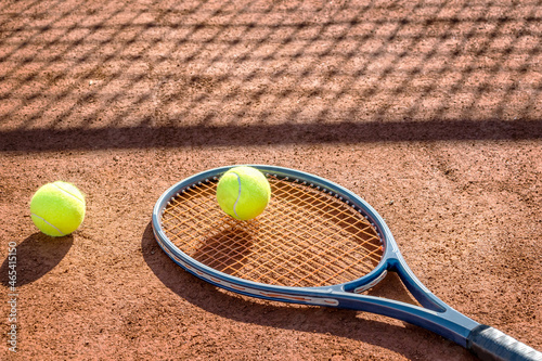 Tennis racket and new tennis ball on a Red clay court. © Ivan