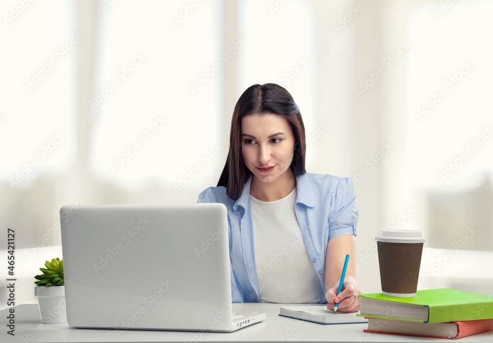 E-Learning. Cheerful Student Girl Taking Notes At Laptop Learning Distantly