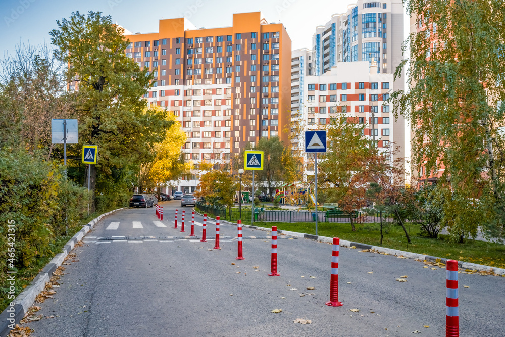 Fototapeta premium Urban development road pedestrian cross with Traffic barriers as poles, and speed dump