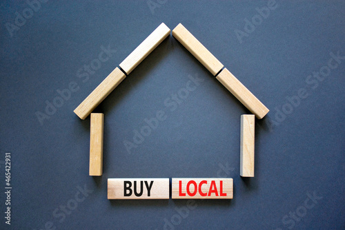 Buy local and house symbol. Concept words 'Buy local' on wooden blocks near miniature house. Beautiful grey background, copy space. Business and buy local house concept.