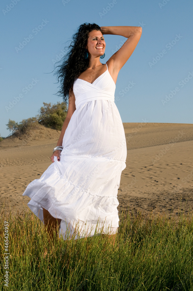woman on sand enjoying spring or summer sun dressed in white clothes woman on sand enjoying spring or summer sun dressed in white clothes
