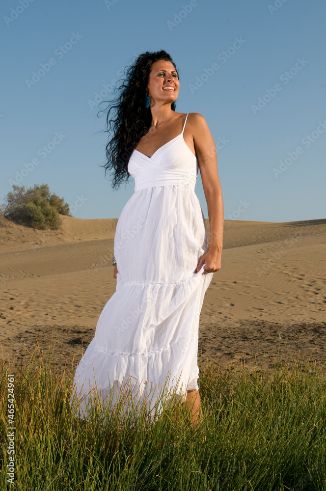 woman on sand enjoying spring or summer sun dressed in white clothes woman on sand enjoying spring or summer sun dressed in white clothes