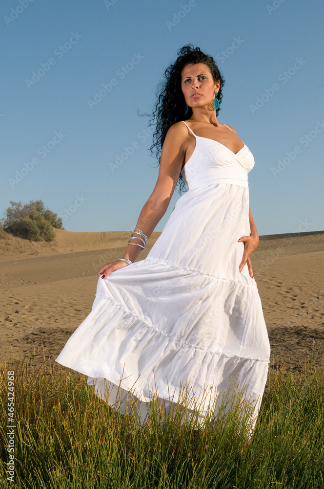 woman on sand enjoying spring or summer sun dressed in white clothes woman on sand enjoying spring or summer sun dressed in white clothes