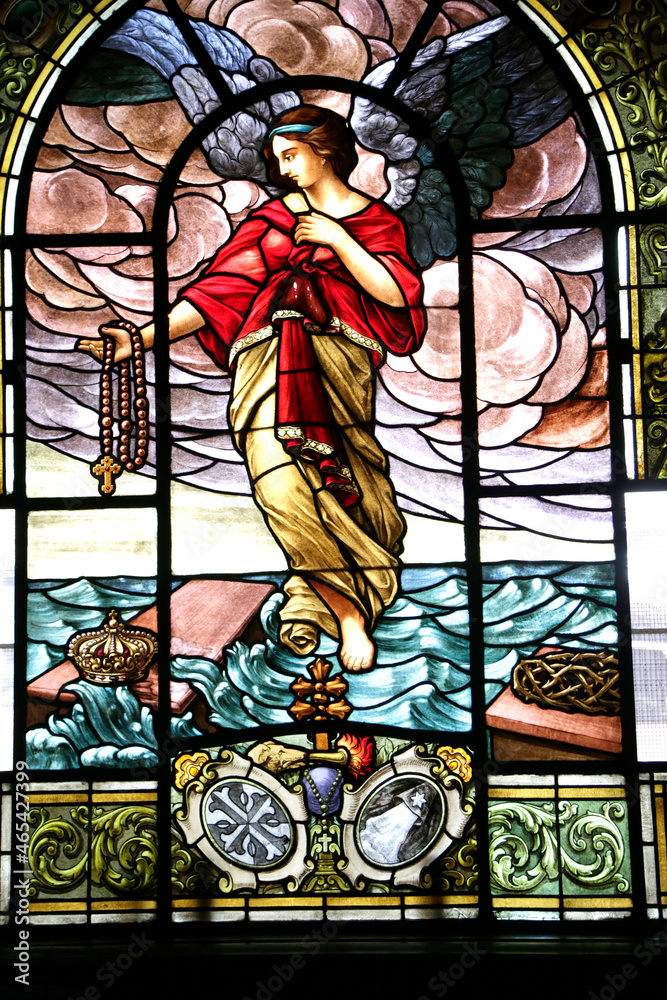 
Stained glass window painted in the Cathedral church of Córdoba Capital, Argentina. Stained glass window of an angel with a rosary in hand. Symbols of the Roman Catholic Apostolic Church. Jesuit chur