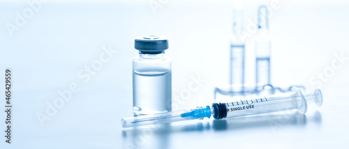 Medical syringe with a needle and a bollte with vaccine.
