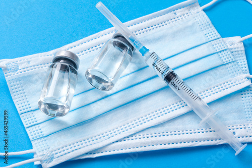 Medical syringe with a needle and a bollte with vaccine.