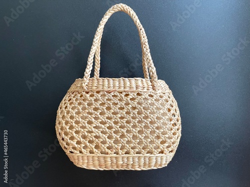 Handmade woven bag made from dried water hyacinth, weaved bag on black background