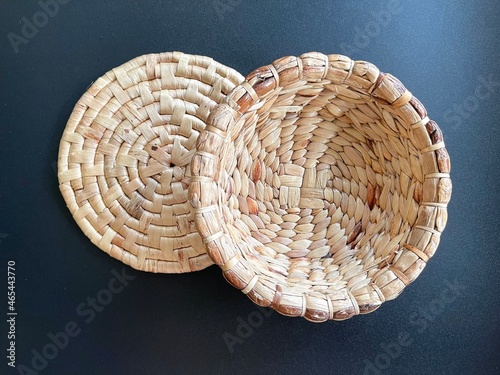 Handmade round shape basket made from dried water hyacinth, woven basket for home use and decoration, weaved basket on black background 