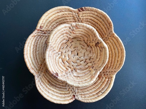 Handmade flower shape basket made from dried water hyacinth, woven basket for home use and decoration, weaved basket on black background