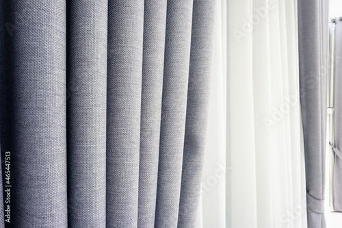 Close up and detail of curtain fabric texture or pattern. That is linen cloth material with gray color for home interior decoration. To blind door or window in room. Look modern style.