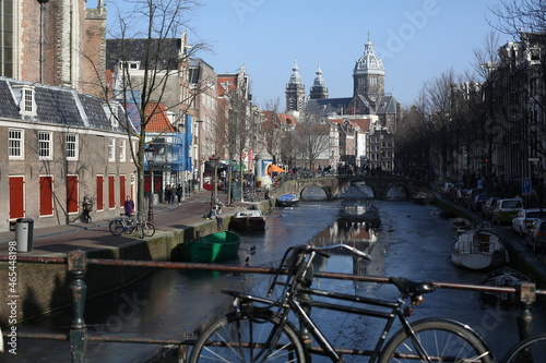 a bicycle parked on the bridge of canal in amsterdam