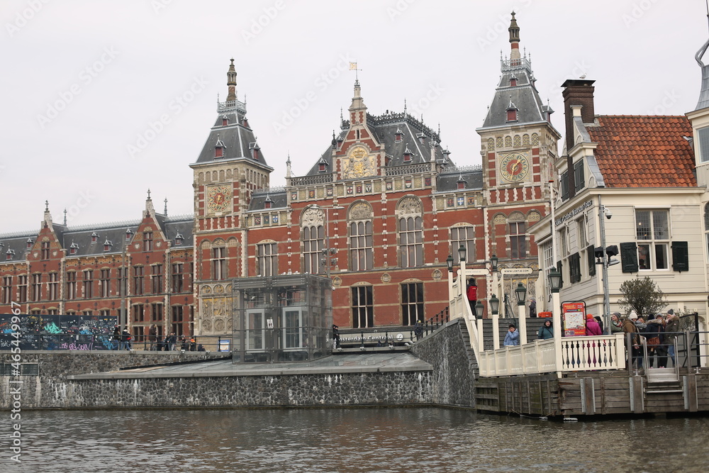 historical architecture of amsterdam station in front of the canal in winter netherlands