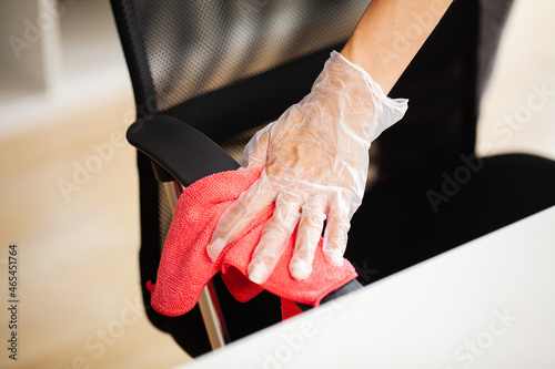 Woman cleaning office chair with a wipe