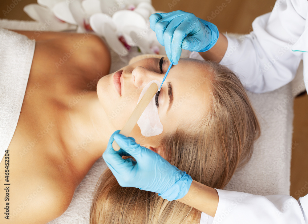 Young woman undergoing procedure of eyelashes lamination in beauty salon Young woman undergoing procedure of eyelashes lamination in beauty salon