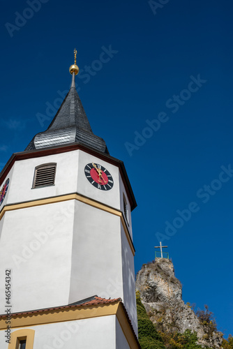 A church tower in Wichsenstein, Germany, Franconian Switzerland with rocks next to it photo