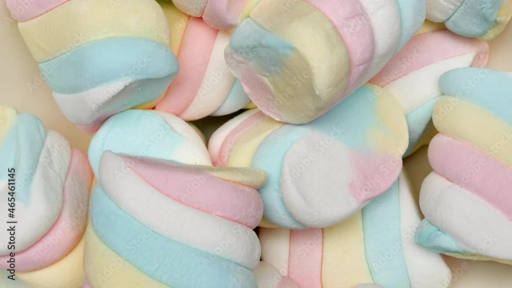 Soft And Delicious Colorful Marshmallows Rotate In A White Dish On A Pink Background. Close Up. Soft And Delicious Colorful Marshmallows Rotate In A White Dish On A Pink Background. Close Up.