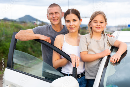 Portrait of a happy family near their new car photo