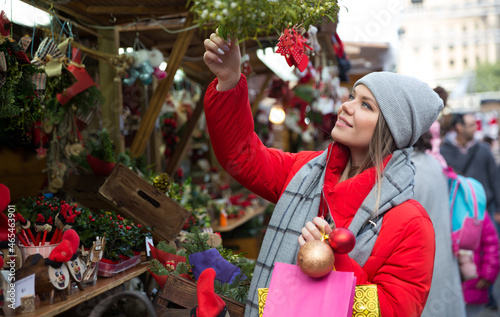 Portrait of young girl choosing xmas gifts on the street market. High quality photo