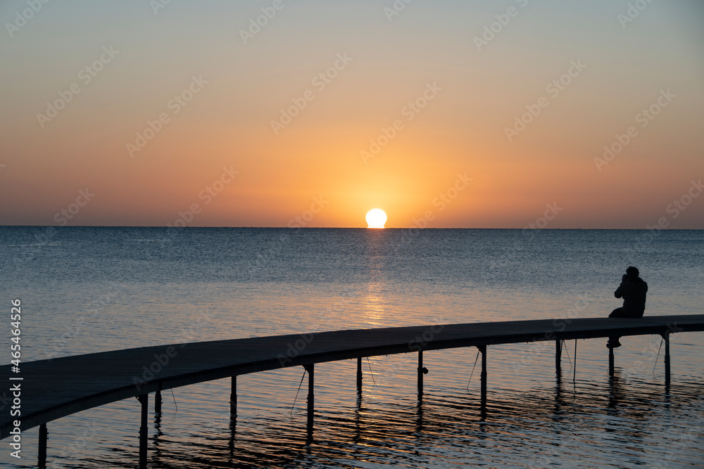 One photographer sitting on a bridge in Scandinavian photographing the sunrice One photographer sitting on a bridge in Scandinavian photographing the sunrice
