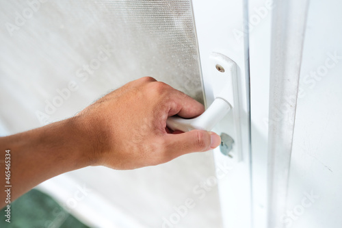 Person hand holding door handle and open it photo