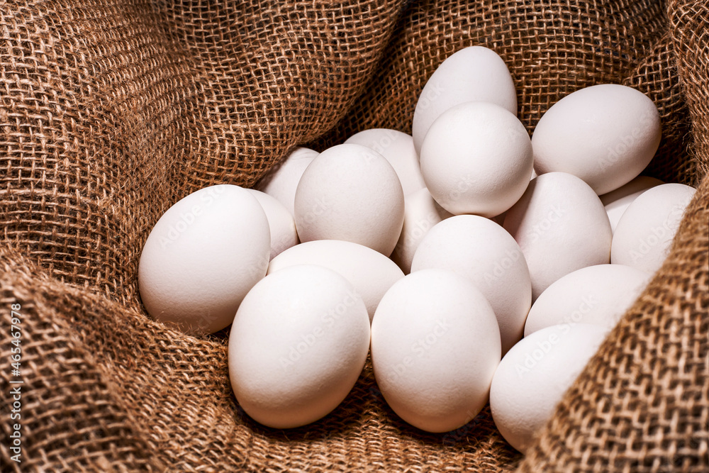 White chicken eggs on a burlap background. White chicken eggs on a burlap background.