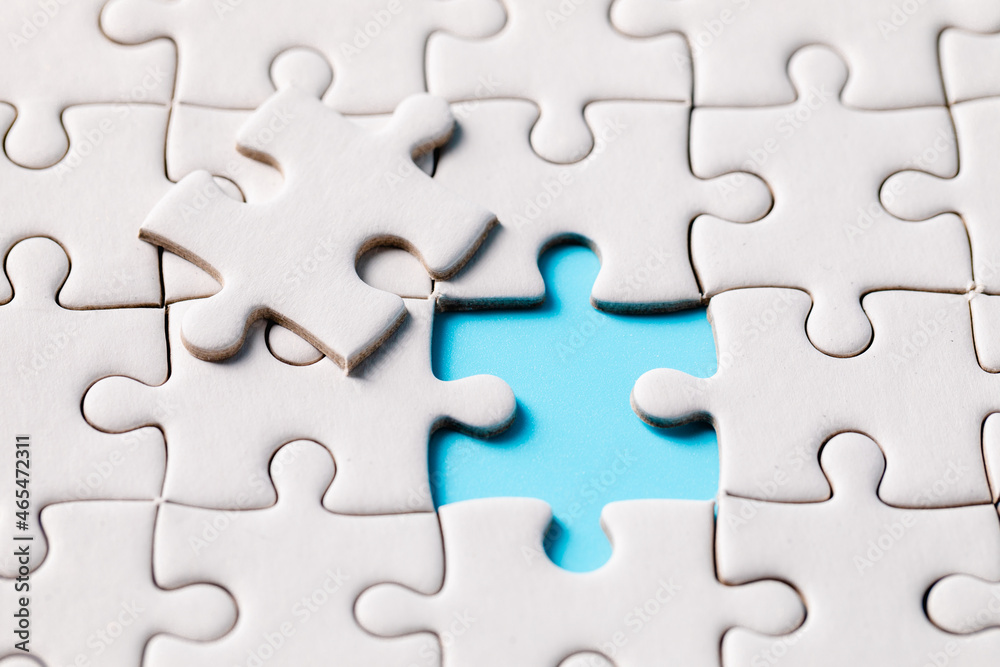 Top view of white jigsaw puzzle connecting pieces of a jigsaw puzzle on a blue background, business connection, partnership or teamwork success, solution, and strategy concept. Top view of white jigsaw puzzle connecting pieces of a jigsaw puzzle on a blue background, business connection, partnership or teamwork success, solution, and strategy concept.