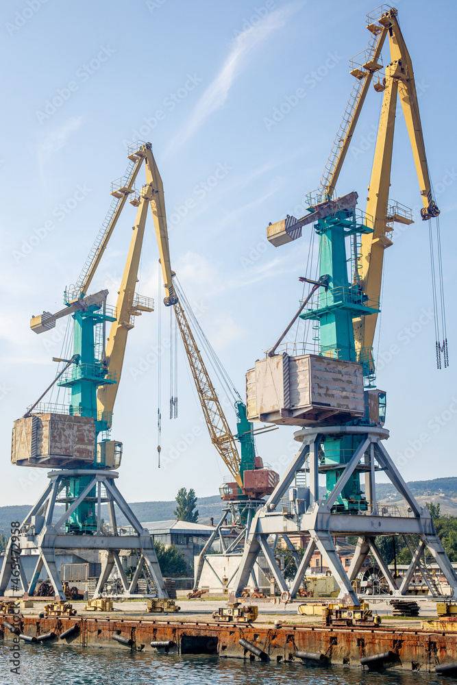 Massive harbor cranes in port. Industrial scene