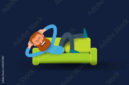 A father with a beard is lazily lying on a green sofa