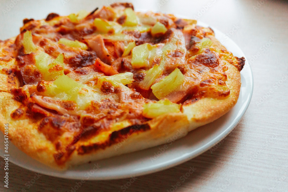 Close up of Pizza with pineapple,  mozzarella cheese, ham, bacon, pizza sauce. Sliced Hawaiian pizza texture, 