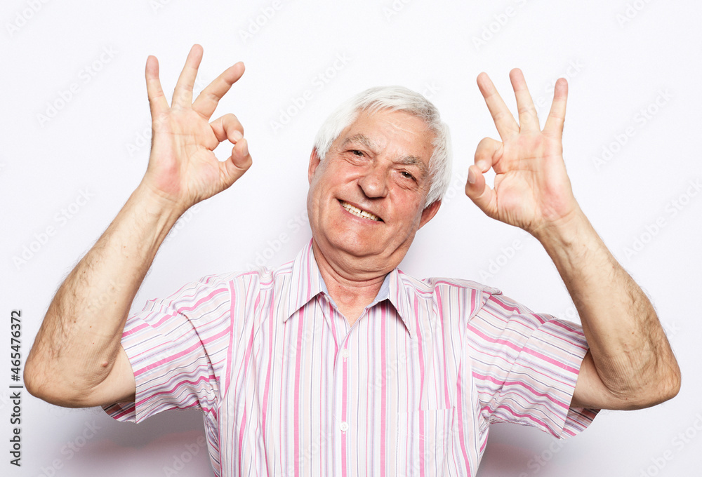 Cheerful cheery confident grey-haired man wearing pink striped shirt showing double ok-sign Cheerful cheery confident grey-haired man wearing pink striped shirt showing double ok-sign