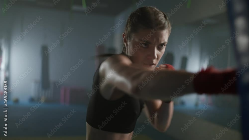 Woman fighter beats a punching bag and trains his punches,, training day in the boxing gym, the female strikes fast, 4k slow motion. Woman fighter beats a punching bag and trains his punches,, training day in the boxing gym, the female strikes fast, 4k slow motion.