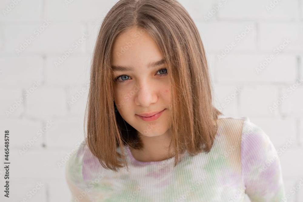 portrait of a slender teenage girl in a light turtleneck in natural light against a white brick wall. natural beauty, no makeup. problematic skin. space for text. High quality photo portrait of a slender teenage girl in a light turtleneck in natural light against a white brick wall. natural beauty, no makeup. problematic skin. space for text. High quality photo
