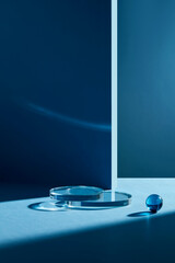 Front view of glass circle podium in blue background with blank space for advertising 