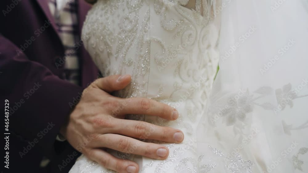 The man puts his arms around the girl's waist, gently touching her