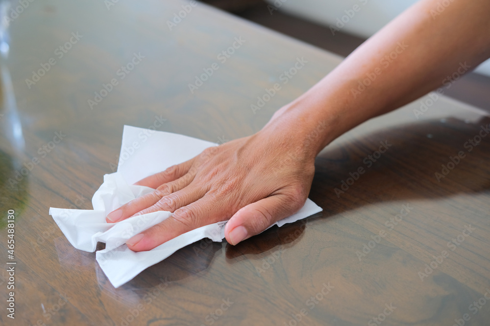 Obraz premium Person hand cleaning up table using tissue