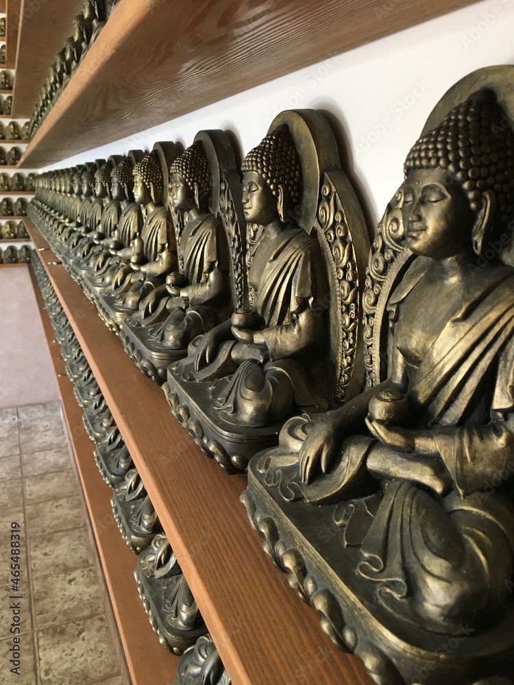 the row of buddha statue on the shelf
