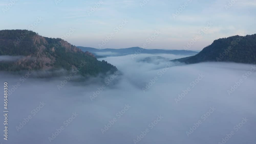 Aerial view over clouds in a valley between Ural mountains on a sunrise Aerial view over clouds in a valley between Ural mountains on a sunrise
