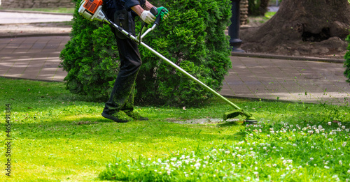 A worker mows the grass