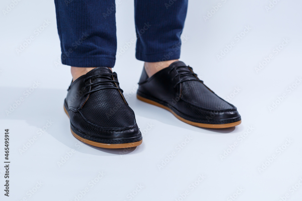 A man is wearing classic black shoes made of natural leather on lace, shoes for men under business style