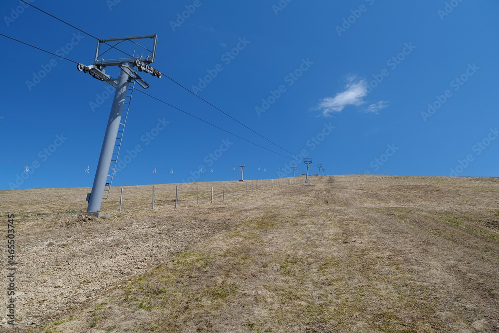 Chair lift on yellow field in mountains