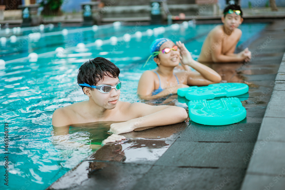 a teenage boy in swimming goggles while standing in the pool
