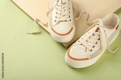Pair of beige sneakers on two tone background