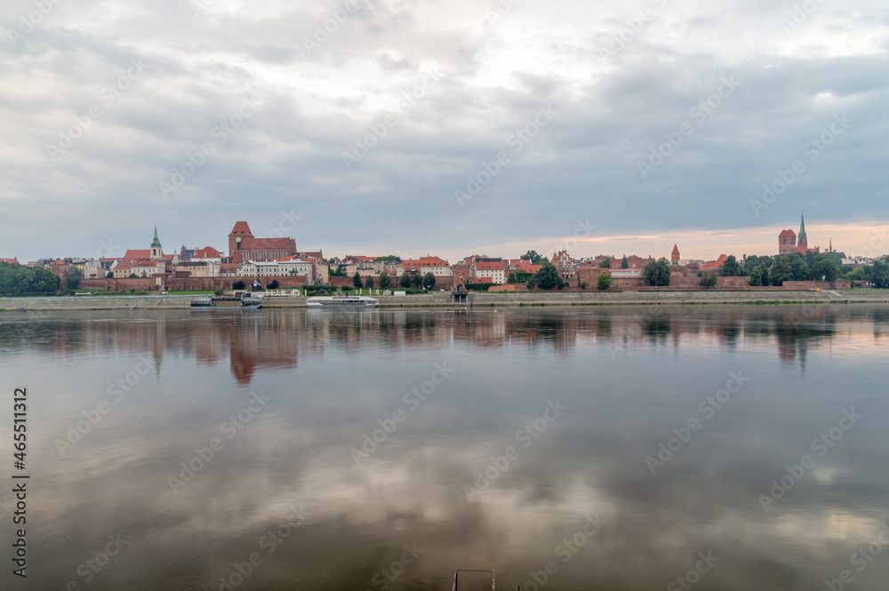 Morning view of panoramic view on Old town of Torun city walls and reflection in Vistula river.